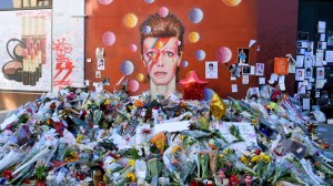 BRIXTON LONDON UNITED KINGDOM- January 28 2016: Flowers left beneath a mural as fans paying tribute to David Bowie in his birthplace. Bowie was born as David Robert Jones in Brixton London UK.