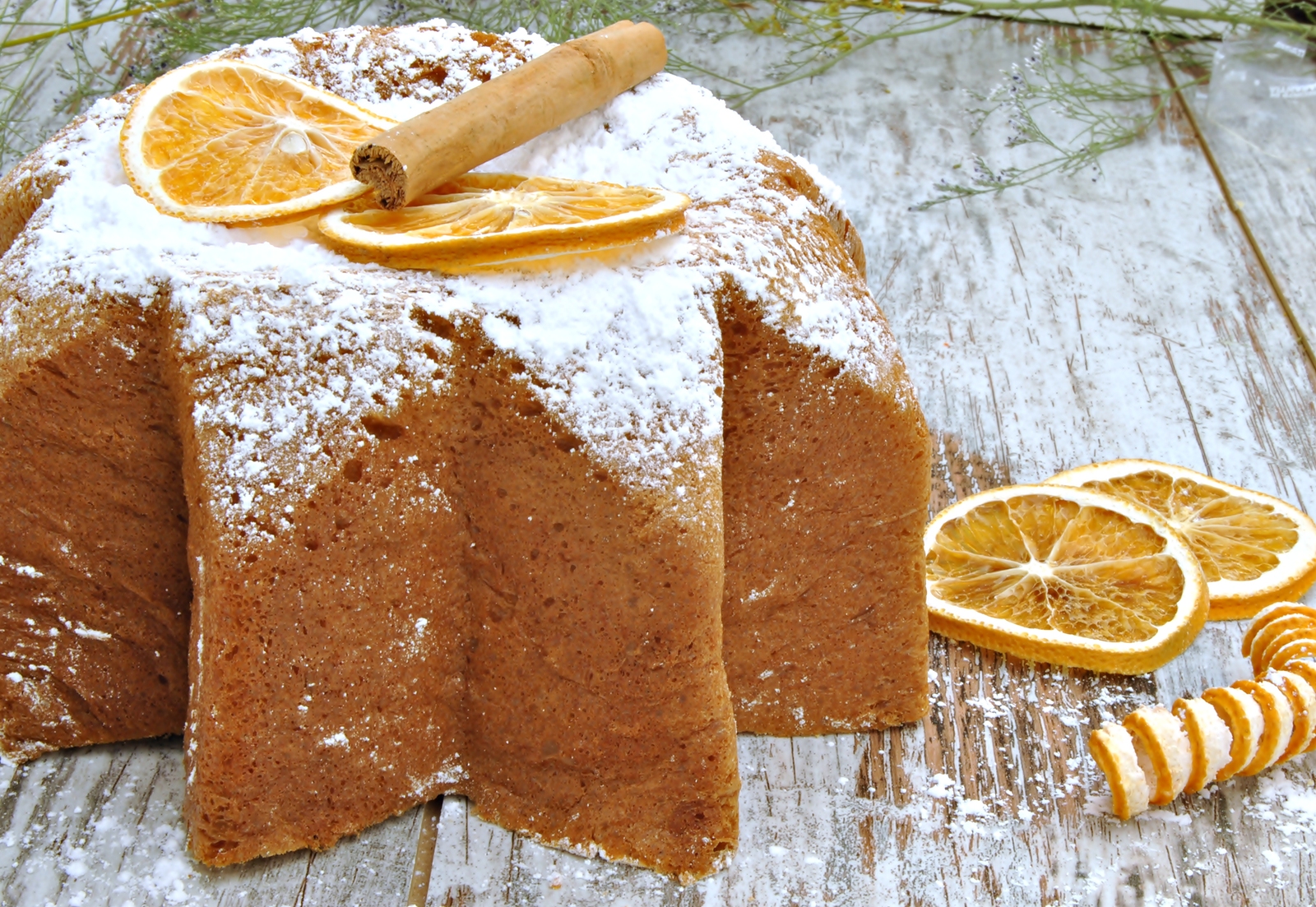 Panneton decorated with orange slices and cinnamon, with sugar on top, rustic background