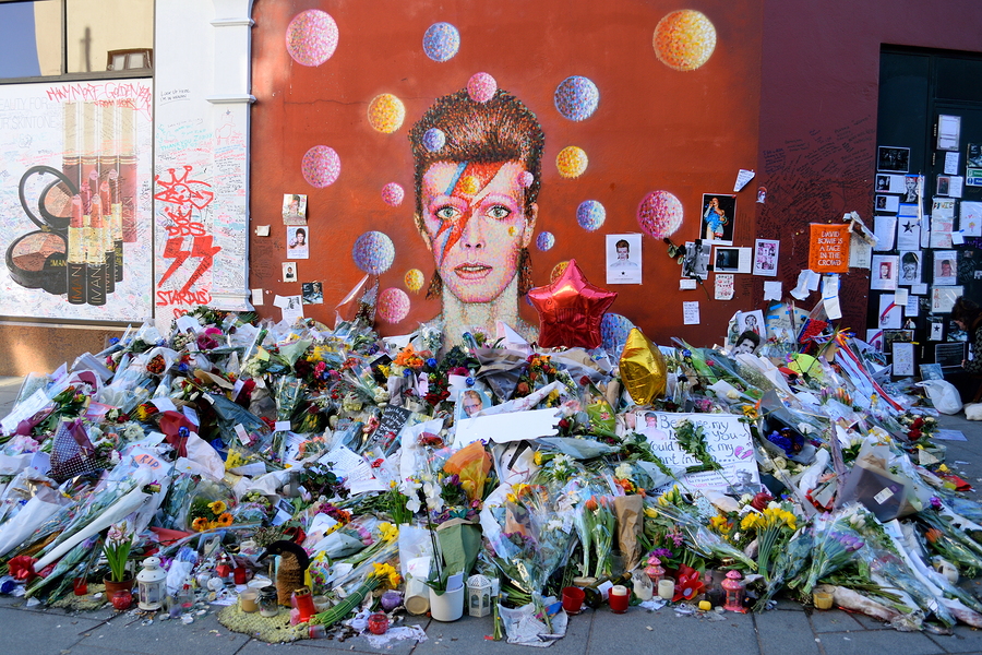 BRIXTON LONDON UNITED KINGDOM- January 28 2016: Flowers left beneath a mural as fans paying tribute to David Bowie in his birthplace. Bowie was born as David Robert Jones in Brixton London UK.