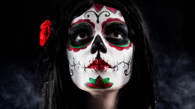 Sugar skull girl with dead roses studio shot over black smoky background ** Note: Slight blurriness, best at smaller sizes